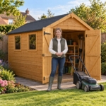 Woman wheeling a lawnmower out of the Hartwell shed double doors
